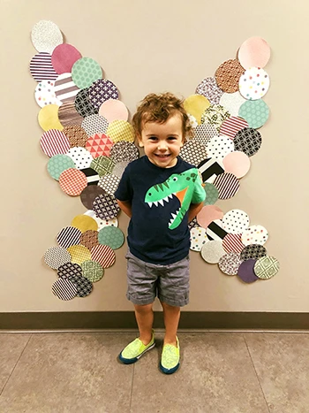 Child poses with butterfly wing art